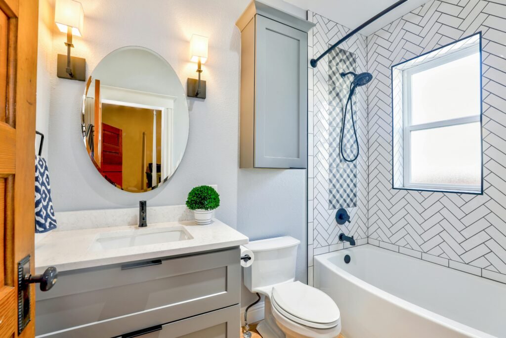 pexels-photo-1910472-1910472 Elegant modern bathroom featuring chevron tiles, oval mirror, and sleek fixtures for a contemporary look.